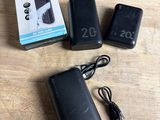 two batteries and a charger sitting on a table next to a box of batteries