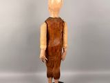 an old wooden doll standing on top of a black base