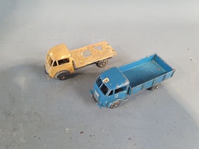 two toy trucks sitting next to each other on a table