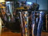 de nombreux verres posés sur une étagère en bois dans une cuisine