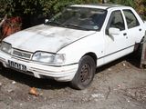a white car that is parked in the dirt