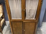 a cabinet with curtains on top of it next to a chair