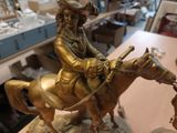 a statue of a man riding a horse on a table