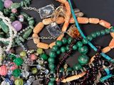 a pile of assorted beads and necklaces on a table