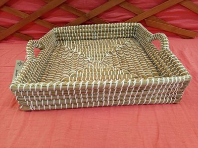un panier en osier posé sur un lit recouvert d'une couverture rouge