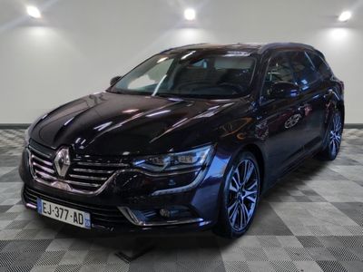 la voiture noire est garée sur un sol en damier dans le garage
