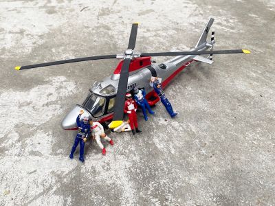 un hélicoptère miniature posé par terre, avec des personnes autour