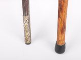 two baseball bats sitting next to each other on a white surface
