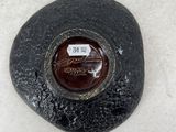 a black rock with a brown button on it