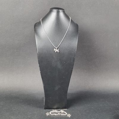 Collier plaqué argent avec pendentif en forme d'éléphant, présenté sur un présentoir pour mannequin