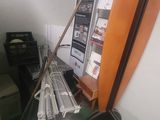 a pile of newspapers sitting on a shelf next to a computer