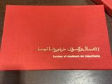 deux cartons rouges portant des inscriptions en arabe, posés sur une table