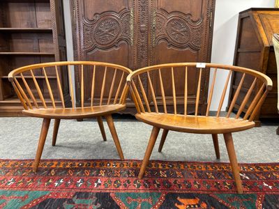 deux chaises en bois posées sur un tapis, à côté d'un meuble en bois