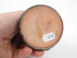 a hand holding a small brown object with writing on it