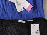 three pairs of blue and black pants with tags on them