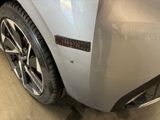 the rear end of a silver car with a sticker on it