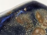 a close up of a blue and black object on a white surface