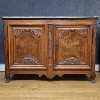 an old wooden cabinet with a marble top on a hard wood floor