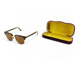 une paire de lunettes de soleil dans un étui, sur fond blanc
