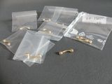 five bags of gold earrings sitting on a table