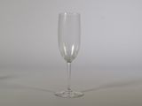 a wine glass sitting on a table with a white wall in the background