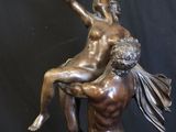 bronze statue of a man holding a woman on his back