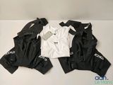 trois paires de vêtements noirs et blancs posées sur une surface blanche