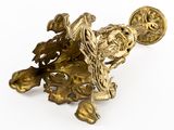 brass figurine of a bird on a branch with leaves and flowers