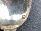 a silver spoon that is sitting on a black surface
