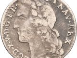 a silver coin with the head of a woman in profile
