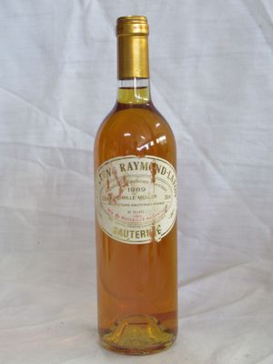 Des bouteilles de vin sont alignées sur une nappe blanche