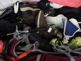 a pile of shoes and other items in a suitcase