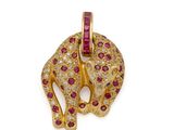Gros plan sur un pendentif en forme d'éléphant en or et rubis, sur fond blanc