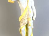 une figurine représentant un homme tenant une orange dans la main