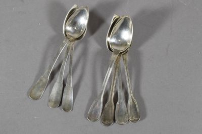 une paire de cuillères en argent et des cuillères à soupe posées sur un plan de travail gris