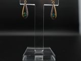 un gros plan sur une paire de boucles d'oreilles posées sur un présentoir