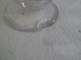un verre avec une cuillère posé sur une surface blanche