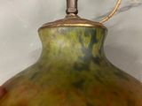 a green and yellow vase with a rope attached to it