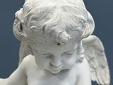 a statue of an angel holding a book on a table