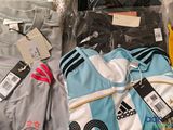 a lot of clothing that is sitting on a bed