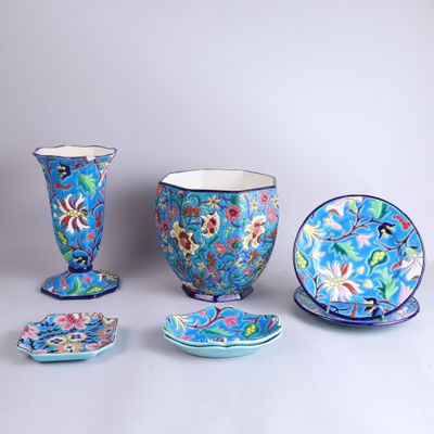 many different pieces of blue and pink pottery on the table