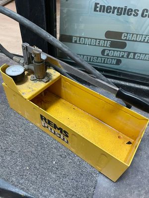 une boîte à outils jaune posée par terre près d'une fenêtre