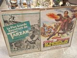 two movie posters on display on the floor