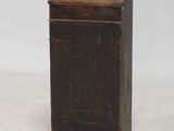 une vieille armoire en bois avec une porte et un tiroir au-dessus
