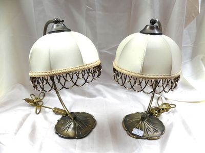 une paire de lampes blanches posées sur une table recouverte d'une nappe blanche