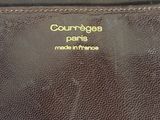 the back of a brown purse with a gold coin on it