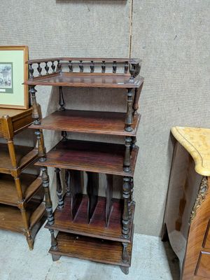 une étagère en bois à trois tablettes et un tableau accroché au mur