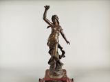 an antique bronze statue of a woman holding a bird on top of a clock