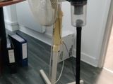 a fan that is sitting on a stand in a room