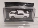 a white toy car in a clear box on a table
